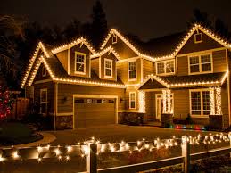 Residential holiday lighting installation with layered roofline accents
